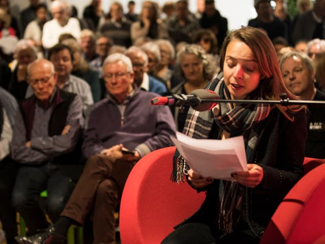 Frau sitzt in rotem Sessel