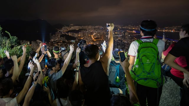 Menschen in der Nacht auf einem Hügel. Sie halten Taschenlampen in die Luft. Menschen in der Nacht auf einem Hügel. Sie halten Taschenlampen in die Luft.