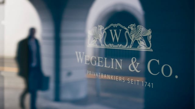 Ein Mann mit Aktentasche wird in einem Fenster der Bank Wegelin gespiegelt. Ein Mann mit Aktentasche wird in einem Fenster der Bank Wegelin gespiegelt.