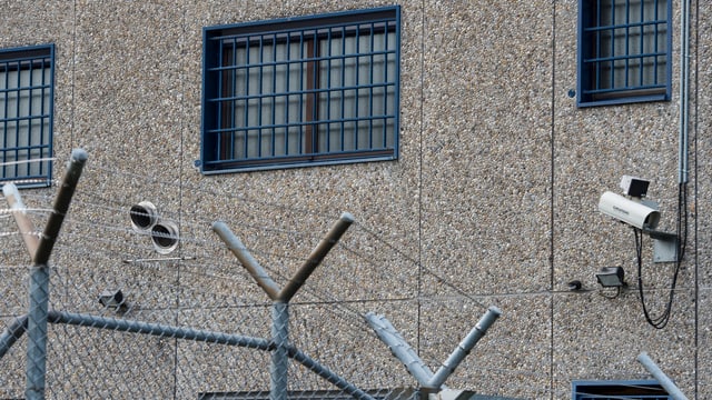 Fassade eines Gefängnisses mit Stacheldraht und vergitterten Fenstern. Fassade eines Gefängnisses mit Stacheldraht und vergitterten Fenstern.