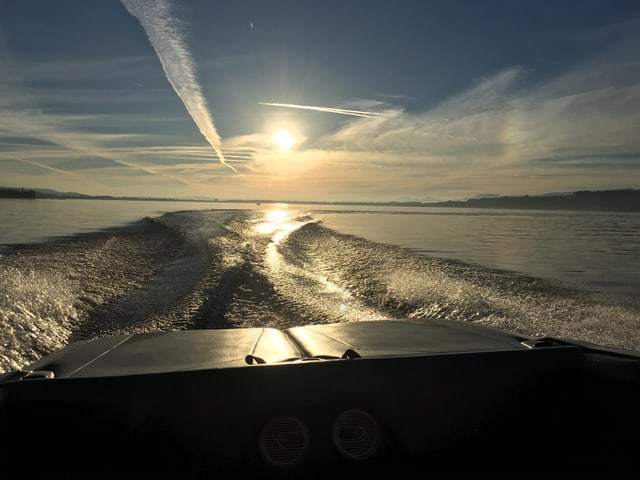 Die Sonne steht tief am Himmel über dem Murtensee