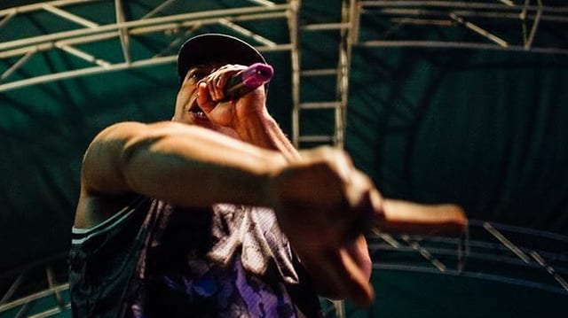 bild von unten eines schwarzen grossen rappers auf der bühne, der rappe rmegaloh aus berlin hier in ugangda bild von unten eines schwarzen grossen rappers auf der bühne, der rappe rmegaloh aus berlin hier in ugangda