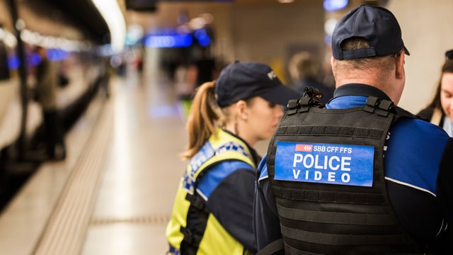 Zwei Polizisten neben einem Zug. Zwei Polizisten neben einem Zug.