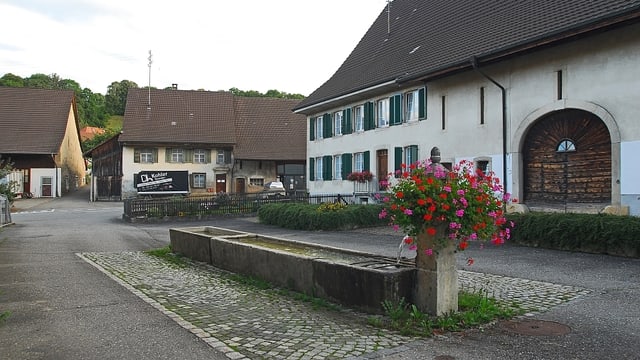 Dorfansicht, alte Häuser, davor ein Brunnen Dorfansicht, alte Häuser, davor ein Brunnen
