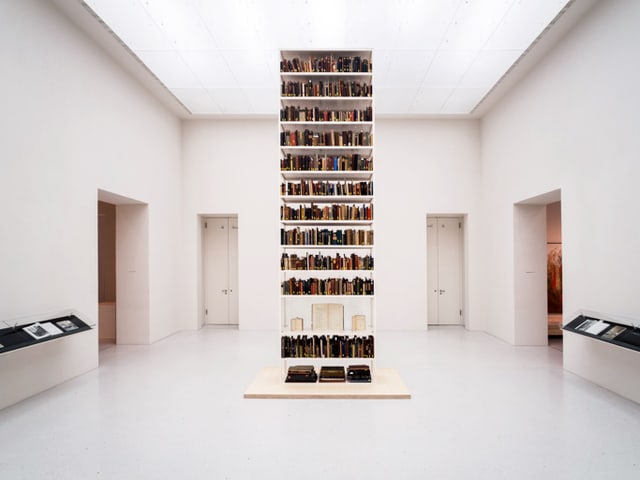 Gefülltes Bücherregal in sonst grossem leeren Raum. Gefülltes Bücherregal in sonst grossem leeren Raum.