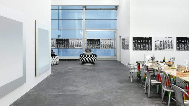 Ein grosser Raum: Darin eine Tafel und schwarz-weisse Bilder an der Wand. Ein grosser Raum: Darin eine Tafel und schwarz-weisse Bilder an der Wand.