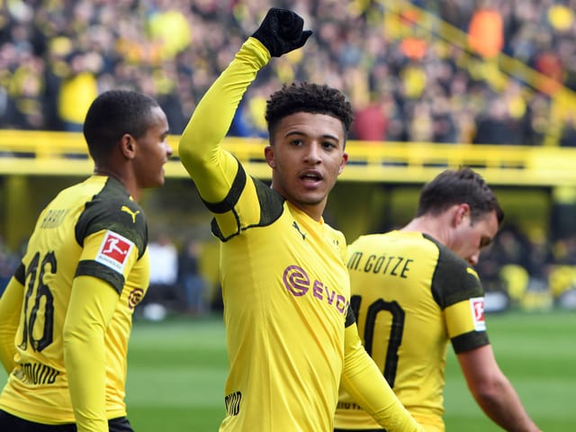 Jadon Sancho reckt auf dem Feld seinen rechten Arm in die Höhe. Jadon Sancho reckt auf dem Feld seinen rechten Arm in die Höhe.