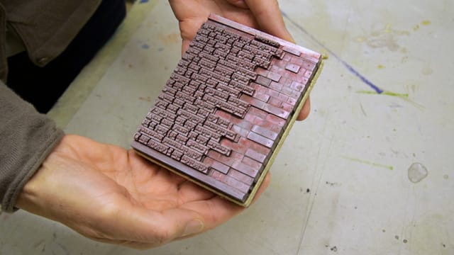 Druckplatte, die jemand in den Händen hält Druckplatte, die jemand in den Händen hält