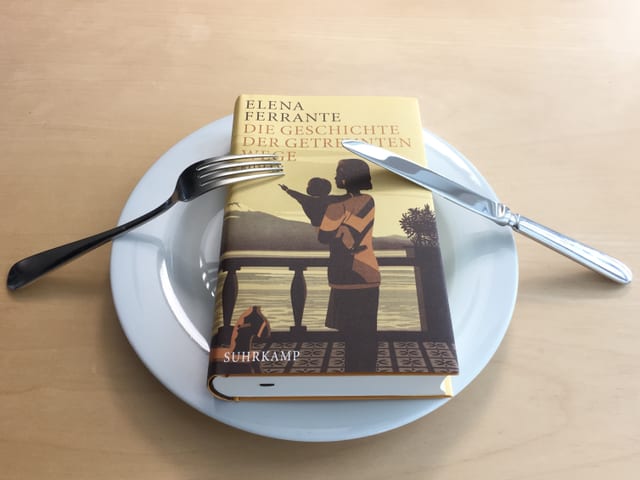 Der Roman «Die Geschichte der getrennten Wege» von Elena Ferrante liegt auf einem Teller Der Roman «Die Geschichte der getrennten Wege» von Elena Ferrante liegt auf einem Teller