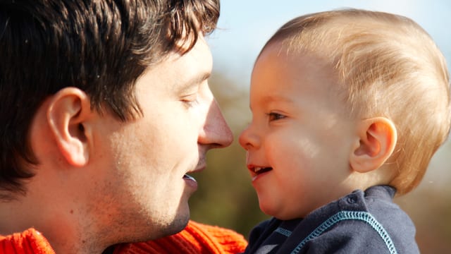 Ein Mann und ein Baby sehen sich in die Augen Ein Mann und ein Baby sehen sich in die Augen