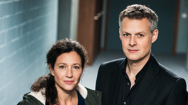 Mayer und Froschmayer stehen nebeneinander in einem Flur. Mayer und Froschmayer stehen nebeneinander in einem Flur.