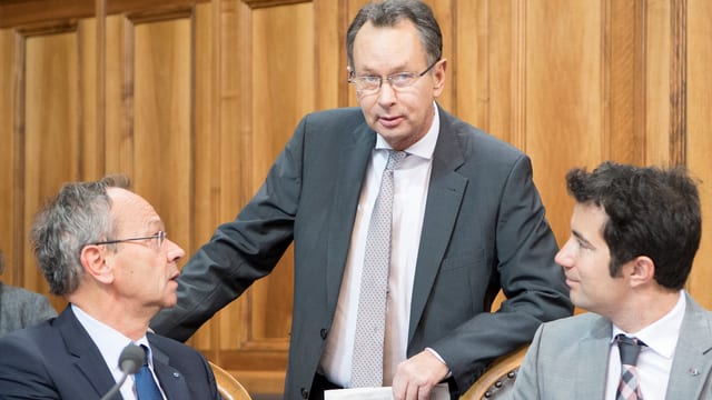 Philipp Müller steht im Ständerat, lins und rechts zwei sitzende Räte. Philipp Müller steht im Ständerat, lins und rechts zwei sitzende Räte.