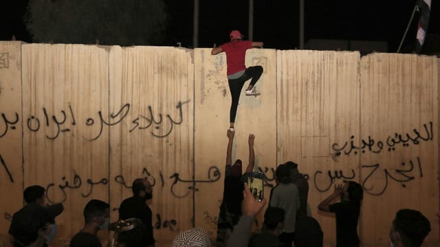 Jemand klettert auf die Mauer um das iranische Konsulat in Kerbela. Jemand klettert auf die Mauer um das iranische Konsulat in Kerbela.