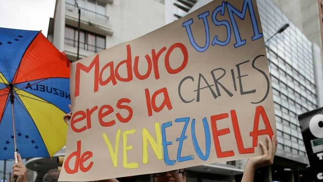 Plakat mit der Aufschrift: Maduro, du bist das Karies von Venezuela. Plakat mit der Aufschrift: Maduro, du bist das Karies von Venezuela.