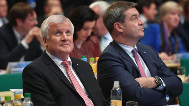 Seehofer und Söder sitzen in einem Saal nebeneinander. Seehofer und Söder sitzen in einem Saal nebeneinander.