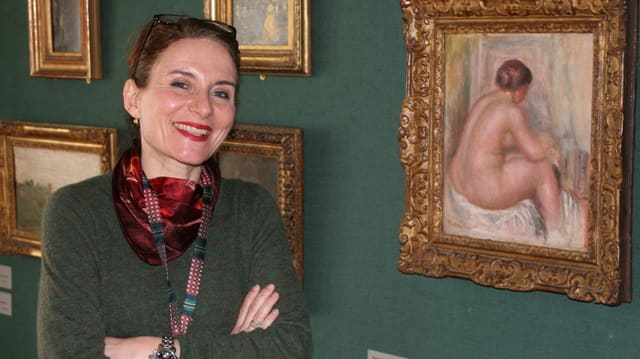 Direktorin Sarah Zürcher vor einer Wand mit Bildern Direktorin Sarah Zürcher vor einer Wand mit Bildern