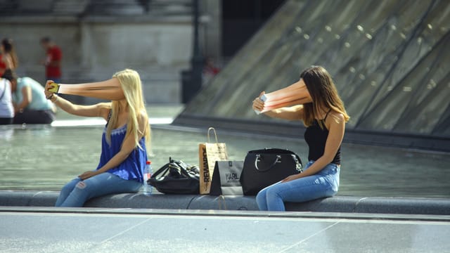 Zwei Frauen mit zum Smartphone hin verzerrtem Gesicht. Zwei Frauen mit zum Smartphone hin verzerrtem Gesicht.