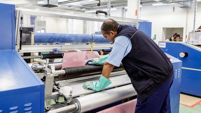 Ein Fabrik-Angestellter an einer Maschine Ein Fabrik-Angestellter an einer Maschine