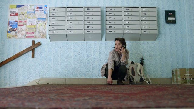 Katja Fedulova sitzt in einem russischen Treppenhaus und telefoniert. Katja Fedulova sitzt in einem russischen Treppenhaus und telefoniert.