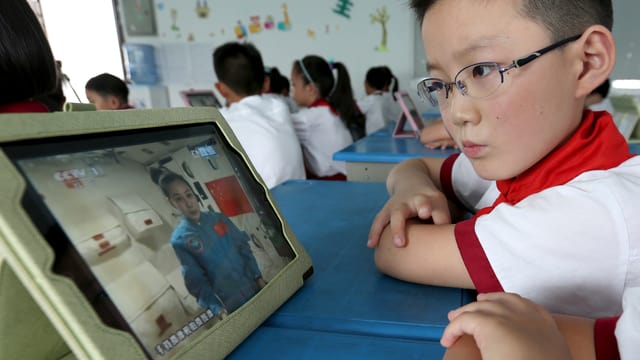 Schüler schaut Vorlesung auf Fernseher. Schüler schaut Vorlesung auf Fernseher.