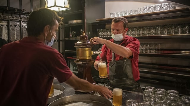 Ein Wirt an einem Bier-Zapfhahn. Ein Wirt an einem Bier-Zapfhahn.