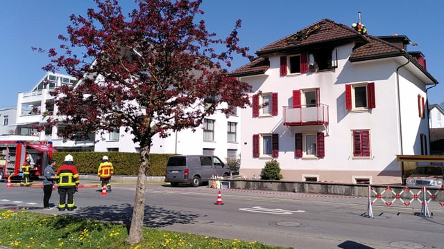 Feuerwehrleute auf dem Dach des beschädigten Hauses Feuerwehrleute auf dem Dach des beschädigten Hauses