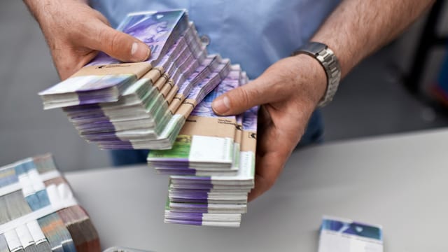 Zwei Hände halten Bündel mit Tausendernoten Zwei Hände halten Bündel mit Tausendernoten
