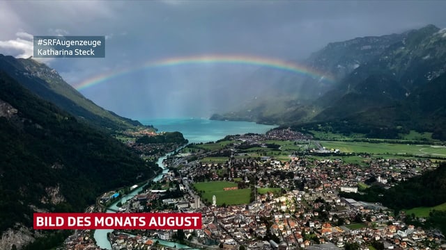 Regenbogen spannt sich über Tal mit See Regenbogen spannt sich über Tal mit See