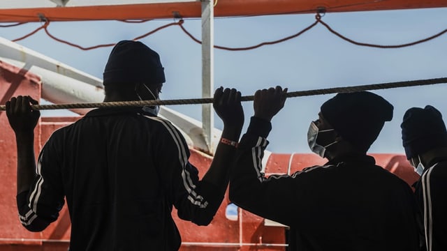 Zwei afrikanische Männer von hinten auf einem Schiff. Zwei afrikanische Männer von hinten auf einem Schiff.