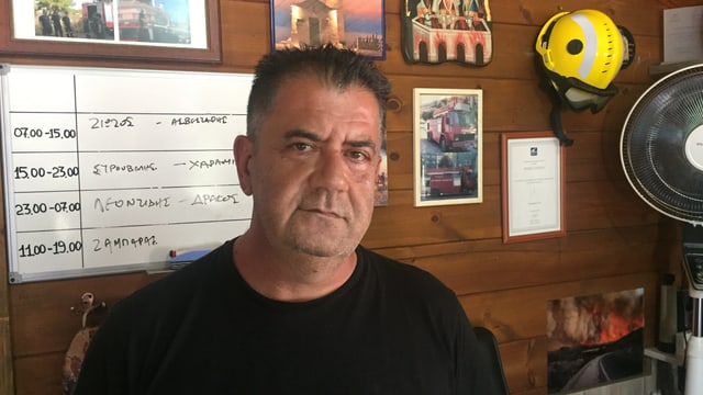 Manos Tsalagios sitzt in einem Büro vor einem Dienstplan. Manos Tsalagios sitzt in einem Büro vor einem Dienstplan.