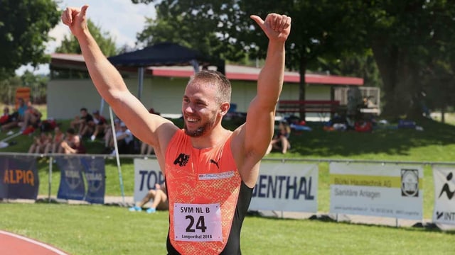 Mann in orangem Dress hält beide Daumen in die Höhe. Mann in orangem Dress hält beide Daumen in die Höhe.