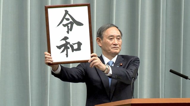 Suga mit der Beschriftung des Reiwa-Zeit in einem Rahmen. Suga mit der Beschriftung des Reiwa-Zeit in einem Rahmen.