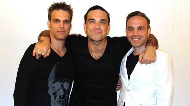Sven Odermatt (links) und Sascha Macina posieren mit Robbie Williams.