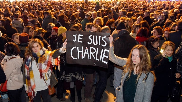 Zwei junge Frauen halten ein Plakat in die Höhe, auf dem Je suis Charlie geschrieben steht. Zwei junge Frauen halten ein Plakat in die Höhe, auf dem Je suis Charlie geschrieben steht.