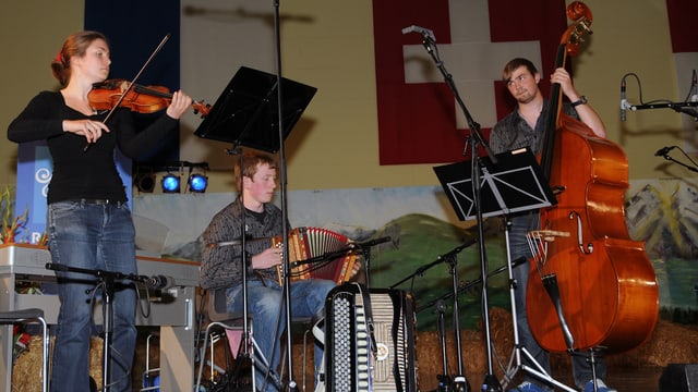 Eine Musikantin mit Geige, ein Musikant am Schwyzerörgeli und der dritte Musikant am Bass. Eine Musikantin mit Geige, ein Musikant am Schwyzerörgeli und der dritte Musikant am Bass.