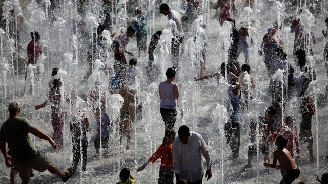 Menschen zwischen kleinen Springbrunnen. Menschen zwischen kleinen Springbrunnen.