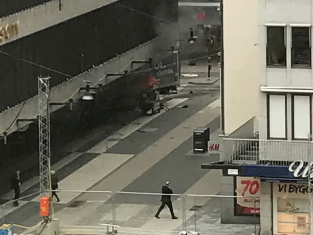 Aus dem ins Gebäude gerasten Lastwagen steigt Rauch. Aus dem ins Gebäude gerasten Lastwagen steigt Rauch.