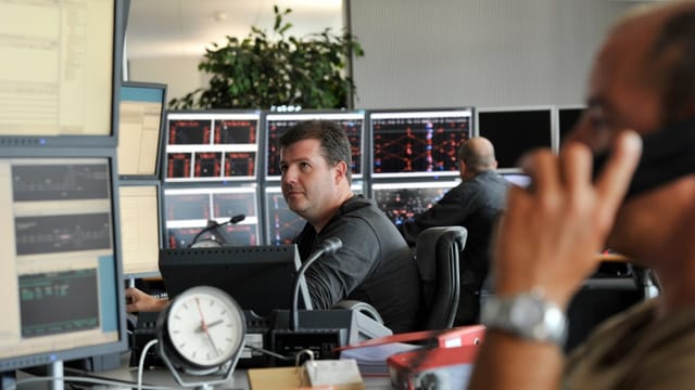 Männer sitzen vor Computerbildschirmen. Männer sitzen vor Computerbildschirmen.