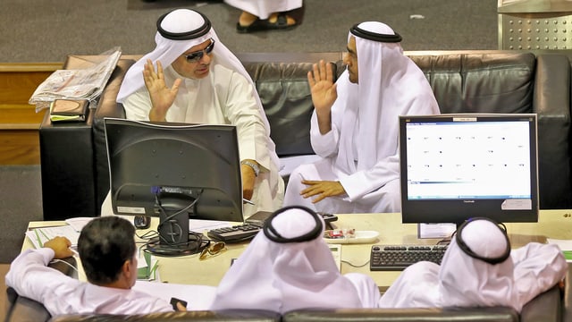 Mehrere Personen an der Dubaier Börse. Mehrere Personen an der Dubaier Börse.