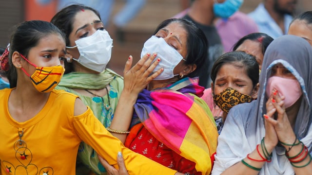 Angehörige trauern in Neu-Delhi um einen Mann, der an Covid-19 gestorben ist. Angehörige trauern in Neu-Delhi um einen Mann, der an Covid-19 gestorben ist.