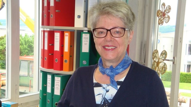 Eine Frau steht vor einem Büchergestell. Eine Frau steht vor einem Büchergestell.