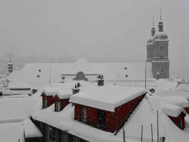 Die Dächer der Stadt sind von einer dicken Schneedecke überzogen.