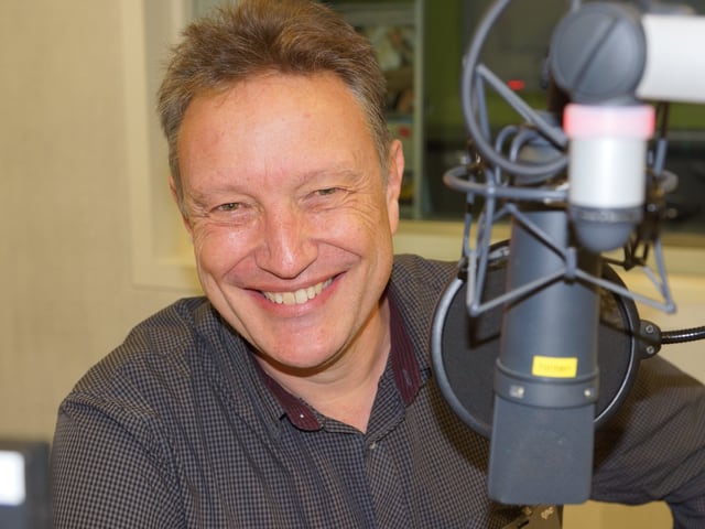 Ein lachender Mann vor einem Mikrofon. Ein lachender Mann vor einem Mikrofon.
