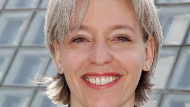 Brigitte Hollinger lächelt in die Kamera, sie trägt Seitenscheitel, hat halblange graue Haare. Brigitte Hollinger lächelt in die Kamera, sie trägt Seitenscheitel, hat halblange graue Haare.