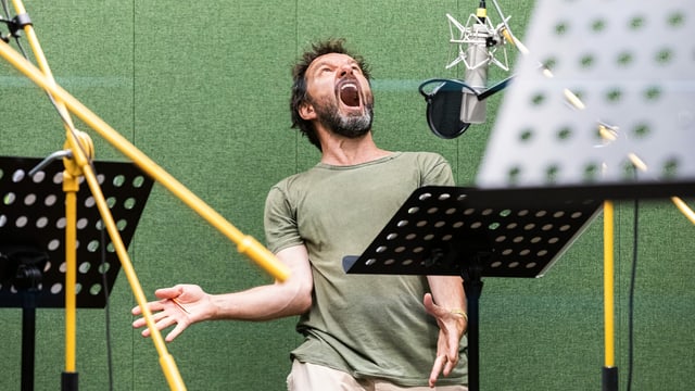 EIn Mann in einem Tonstudio, mit weit aufgerissenem Mund EIn Mann in einem Tonstudio, mit weit aufgerissenem Mund
