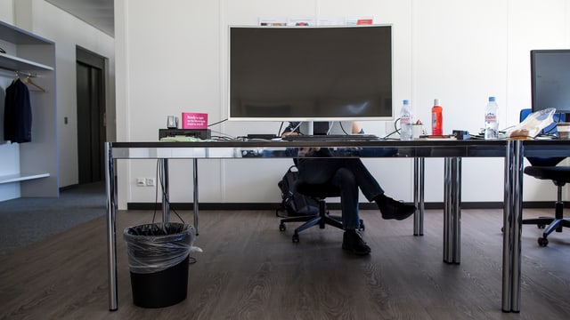Ein Mann sitzt hinter einem Bildschirm und arbeitet. Ein Mann sitzt hinter einem Bildschirm und arbeitet.