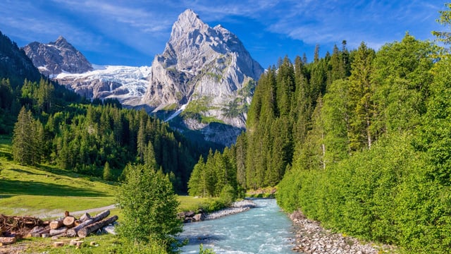Grünes Bergtal mit Bach und markantem Berg in der Ferne mit Gletscher. Grünes Bergtal mit Bach und markantem Berg in der Ferne mit Gletscher.
