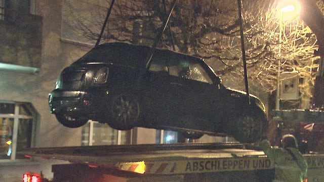 Das Fluchtfahrzeig, ein dunkler Mini, wird auf den Abschleppwagen gehievt. Das Fluchtfahrzeig, ein dunkler Mini, wird auf den Abschleppwagen gehievt.