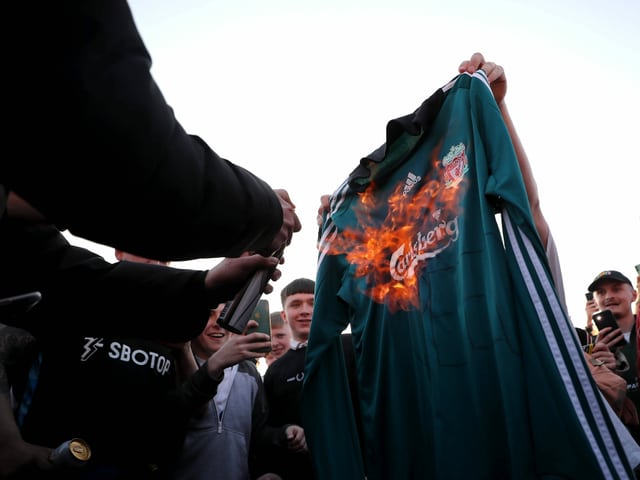 Liverpool-Anhänger zünden ein Liverpool-Trikot an Liverpool-Anhänger zünden ein Liverpool-Trikot an