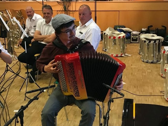 Akkordeonist mit rot gelb orangefarbenem Instrument. Akkordeonist mit rot gelb orangefarbenem Instrument.